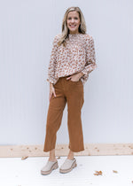 Model with hand in pocket of camel cropped pants with wide legs and tummy control. 