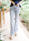 Model wearing light wash bootcut jeans with tummy control and a high waisted fit.