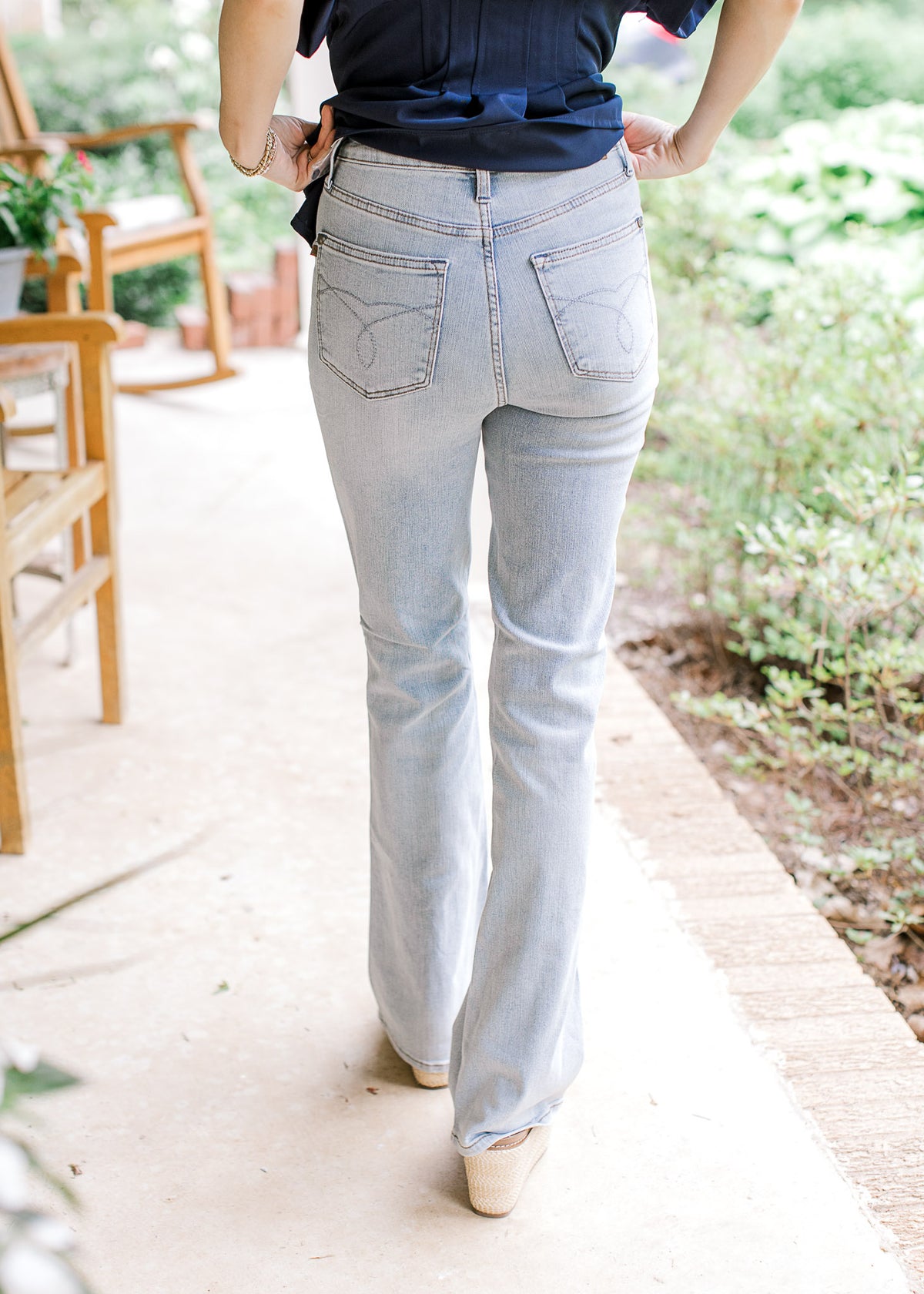 Back view of Model wearing light wash bootcut jeans with tummy control and a high waisted fit.