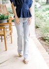 Model wearing wedges and light wash bootcut jeans with tummy control and a high waisted fit.