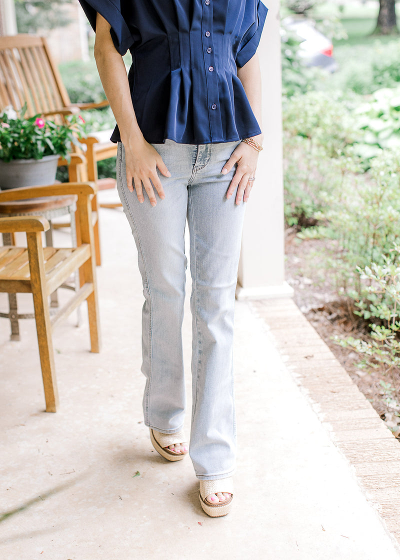 Model wearing wedges and light wash bootcut jeans with tummy control and a high waisted fit.