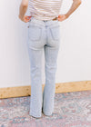Back view of Model wearing lightwash bootcut jeans with side slits and a built in tummy control. 