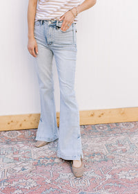 Model wearing lightwash bootcut jeans with side slits and a built in tummy control. 