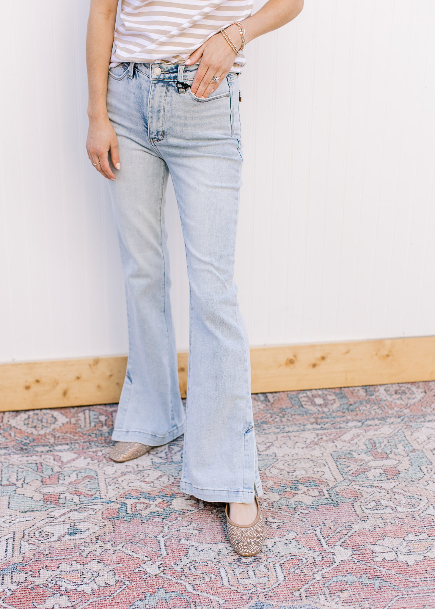 Model wearing lightwash bootcut jeans with side slits and a built in tummy control. 