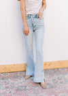 Model wearing a tee and lightwash bootcut jeans with side slits and a built in tummy control. 