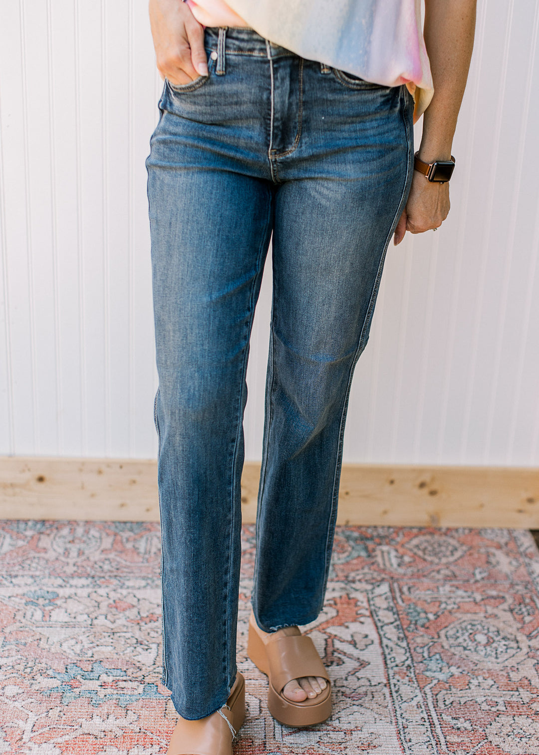 Model wearing Judy blue medium washed straight jeans with a raw hem.
