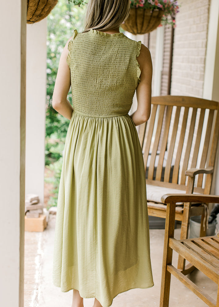 Back view of kiwi green midi with smocked bodice, ruffle at neck and sleeve and fully lined. 