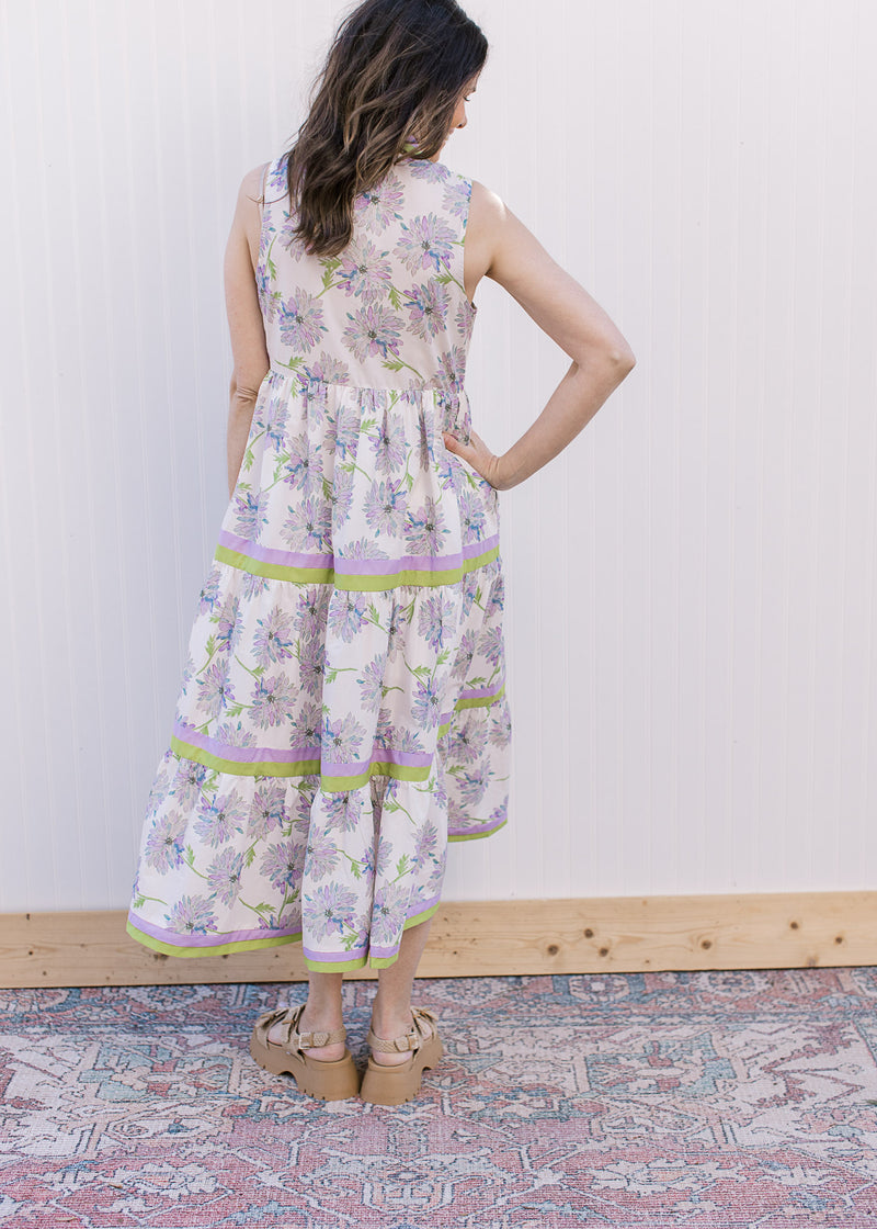 Back view of Model wearing a cream maxi with lavender floral and lavender and lime tiered trim.