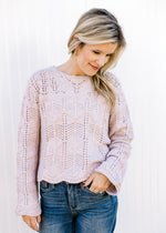 Model wearing a lavender sweater with open weave design, scalloped hem and long sleeves.