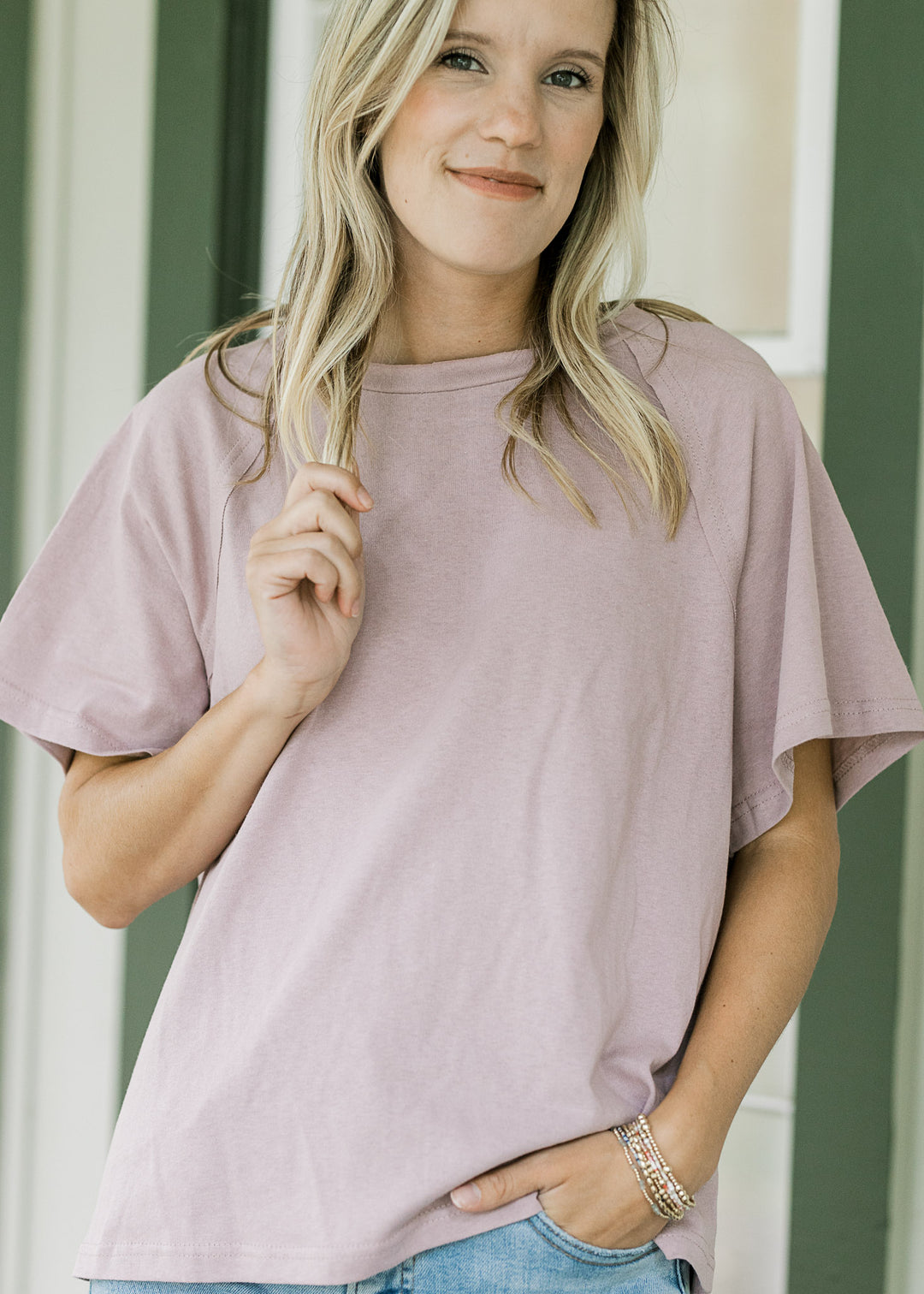Model wearing a lavender tee with round neck, short sleeves and a loose fit. 