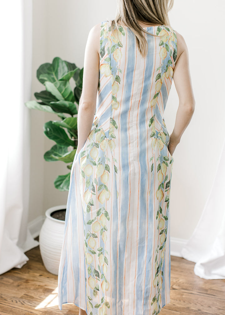 Back view of Model wearing a white and blue striped midi with lemon detail on the outside edges. 