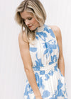 Close up of mock neck and elastic waist on a sleeveless white maxi with light blue floral. 