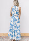 Back view of model wearing a white maxi with light blue floral, an elastic waist and racer back.