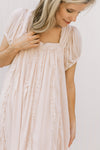 Close up of square neck and ruffle detail on a blush above the knee dress. 