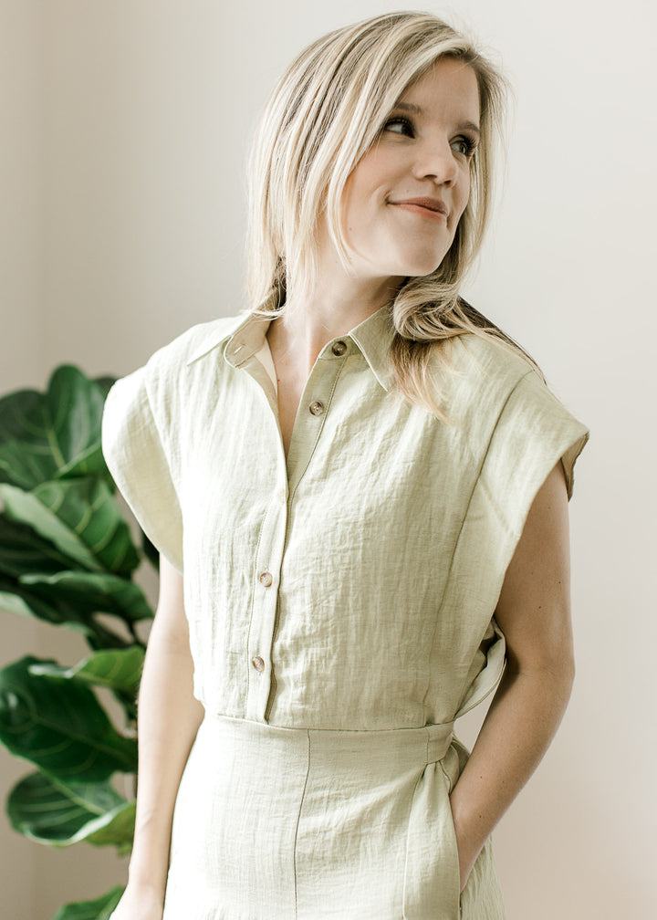 Close up of cap sleeves, collar, button front and a flow skirt on a light olive midi. 