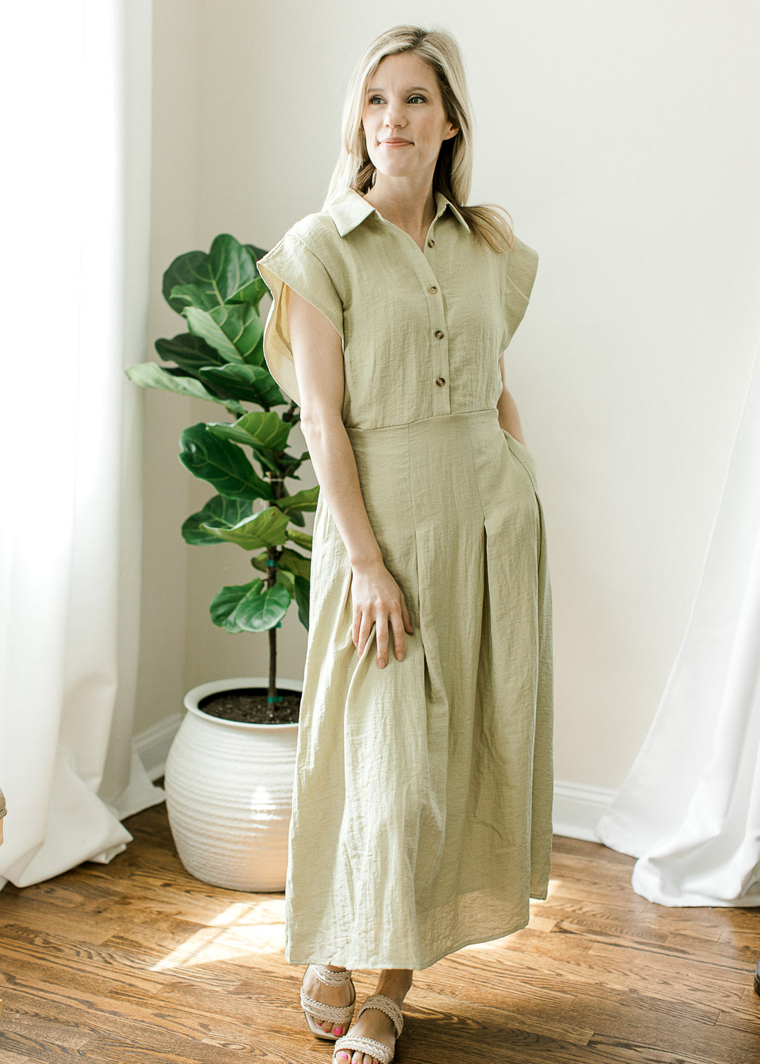 Model wearing sandals and a light olive midi with a buttons, cap sleeves and elastic waist with tie.