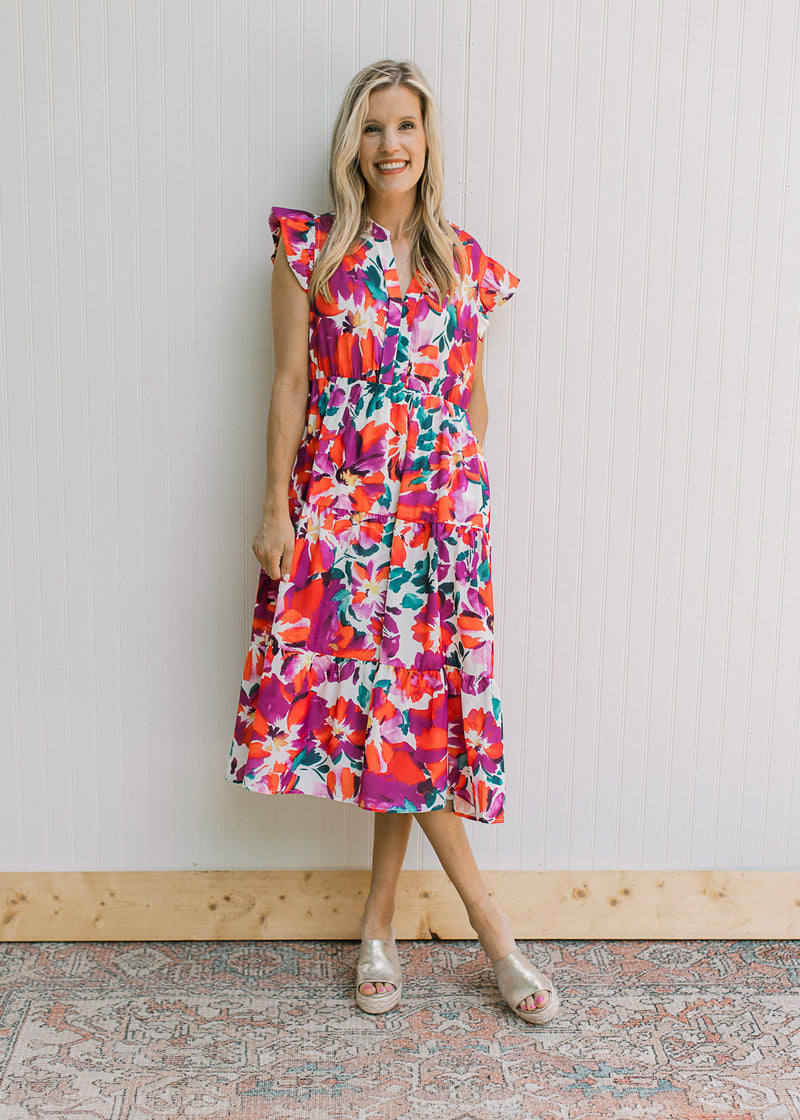 Model wearing wedges with a white dress with magenta flowers and ruffle cap sleeve.