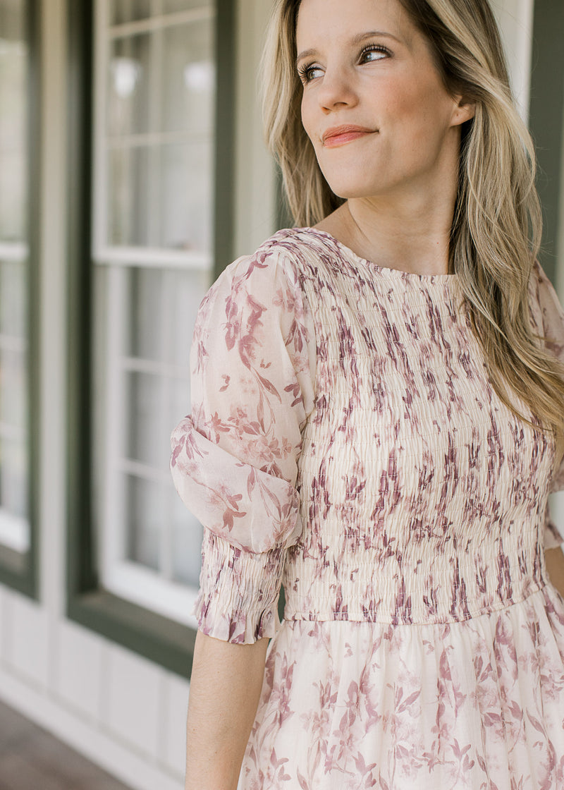 Close up of 3/4 sheer poet sleeve and smocked bodice on a cream midi with dusty mauve floral.