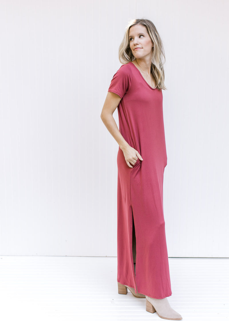 Model wearing a soft maroon v-neck maxi with short sleeves, polyester material and split side hem. 
