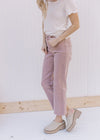 Model wearing a white top, mules and mauve mid rise jeans with a cropped fit.