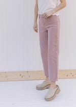 Model wearing mules with mauve mid rise jeans with a cropped fit and button/zip closure.