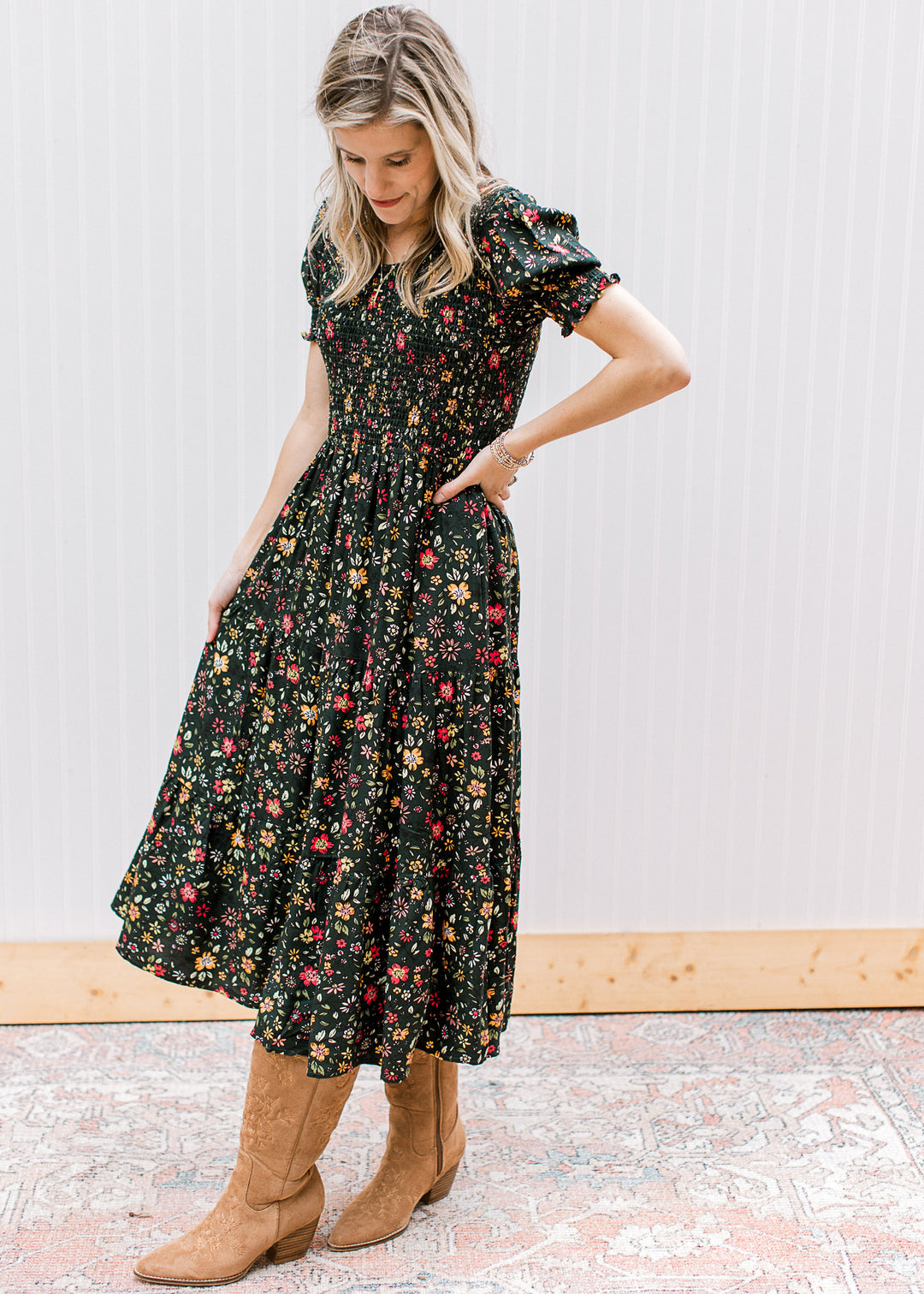 Side view of a hunter green midi with warm floral, smocked bodice, round neck and short sleeves.