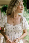 Close up of smocked bodice and sweetheart neck on a cream maxi with lavender floral. 