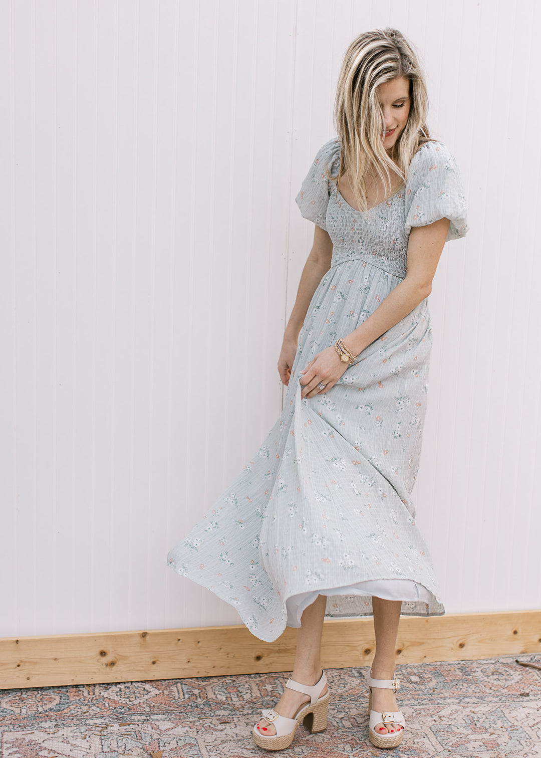 Model wearing a pale blue maxi with a smocked bodice, v-neck and bubble short sleeves. 
