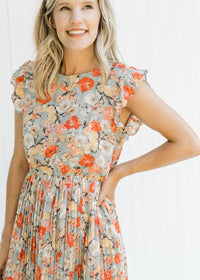 Close up of ruffle capped sleeve on a mint dress with a salmon, taupe and cream floral pattern