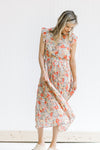 Model wearing a mint dress with a floral pattern, an elastic waistband and ruffle capped sleeves. 