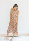 Model wearing heels with a midi mint dress with a floral pattern and ruffle capped sleeves. 