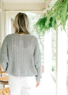 Back view of Model wearing a mint knit sweater with long sleeves and three button closure.  