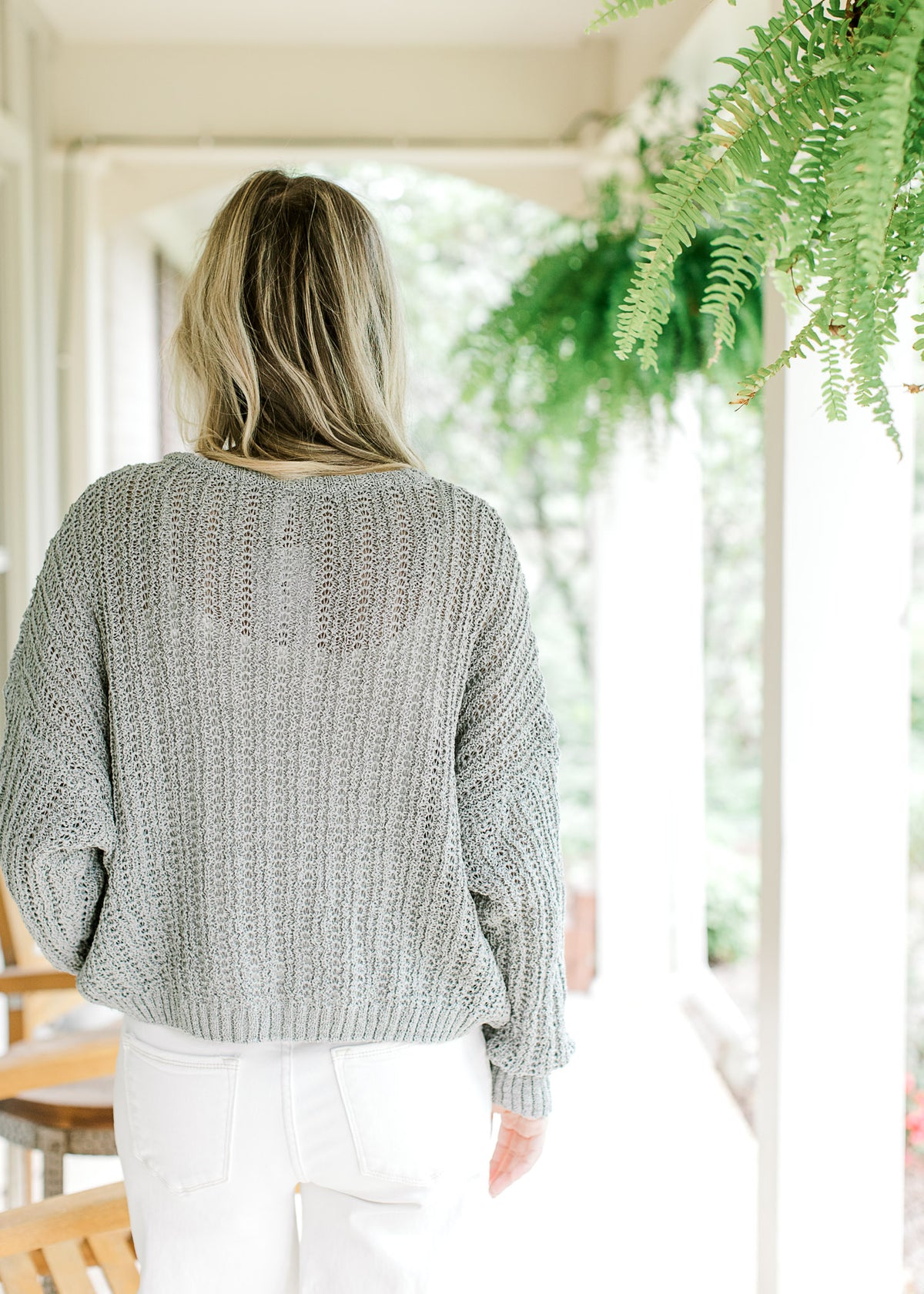 Back view of Model wearing a mint knit sweater with long sleeves and three button closure.  