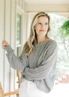 Model wearing a mint knit sweater with long sleeves, ribbed cuffs and three button closure.  
