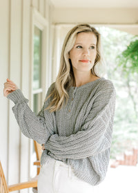Model wearing a mint knit sweater with long sleeves, ribbed cuffs and three button closure.  