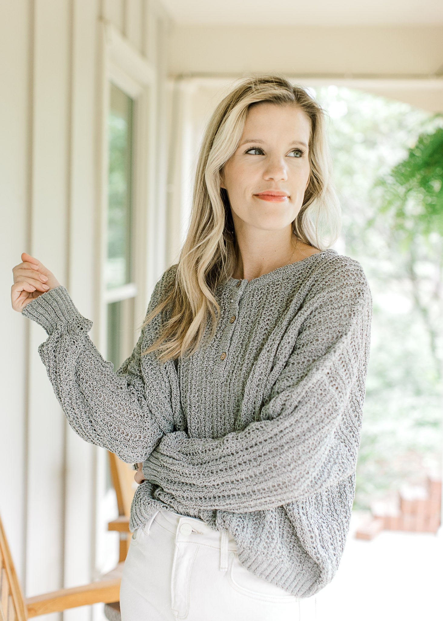 Model wearing a mint knit sweater with long sleeves, ribbed cuffs and three button closure.  