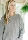 Model wearing a loose fit mint knit sweater with long sleeves and three button closure.  