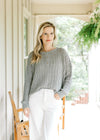 Model wearing a mint sweater with loose knit makeup, long sleeves and three buttons.