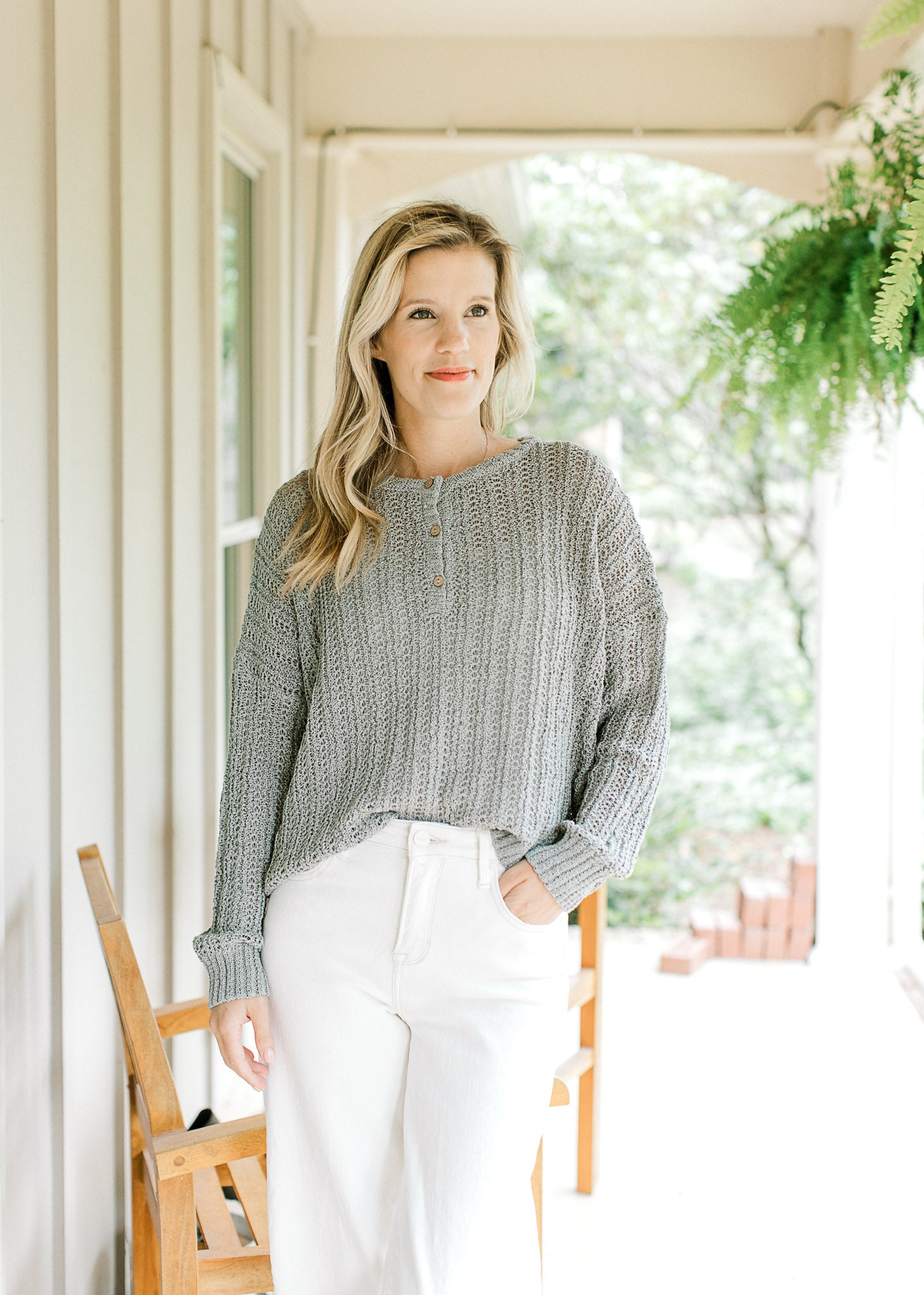 Model wearing a mint sweater with loose knit makeup, long sleeves and three buttons.
