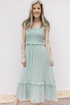 Model wearing a mint midi with a smocked bodice, square neckline and ruffled spaghetti straps.