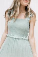 Close up of smocked bodice and ruffled spaghetti straps on a mint colored midi with a square neck.