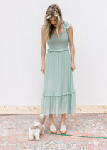 Model wearing sandals with a mint midi with a smocked bodice and ruffled spaghetti straps.