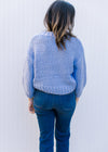 Back view of Model wearing a soft blue knit sweater with 3/4 sleeves and a round neck.