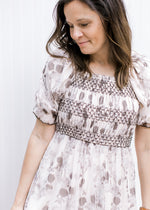 Close up of smocked bodice and bubble short sleeves on a cream midi with gray abstract floral.