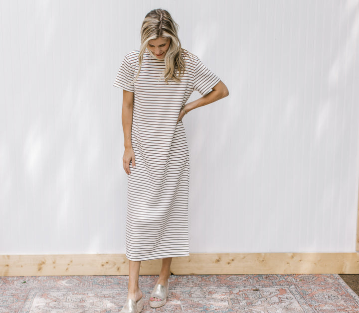 Model wearing wedges with a white midi with mocha stripes, short sleeves and a round neck.
