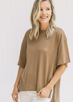 Close up view of model wearing a mocha tee with a high low cut, exposed hem and split sides