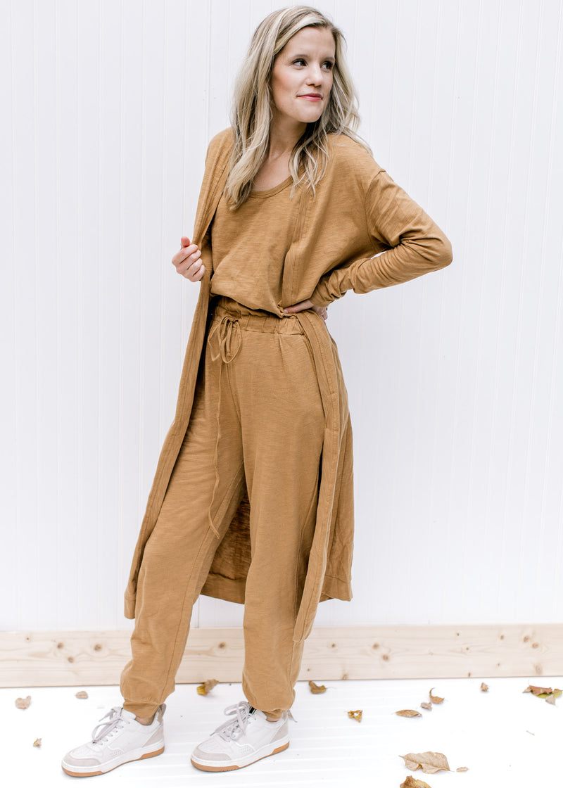Model wearing a mocha one piece sleeveless jumper with pockets and a matching cardigan. 