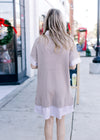 Back view of Model wearing a faux shirt in taupe and white stripe with a taupe sweater overlay.