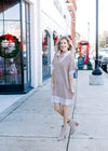 Model wearing booties and a faux shirt with taupe and white stripe and a taupe sweater overlay.