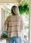 Back view of taupe woven top with short sleeves and brown and gray stripes. 